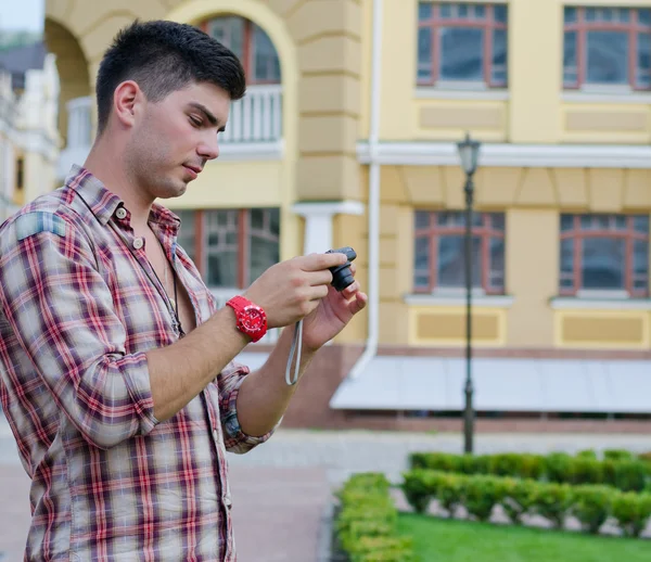 Homem verificando a parte de trás de sua câmera — Fotografia de Stock