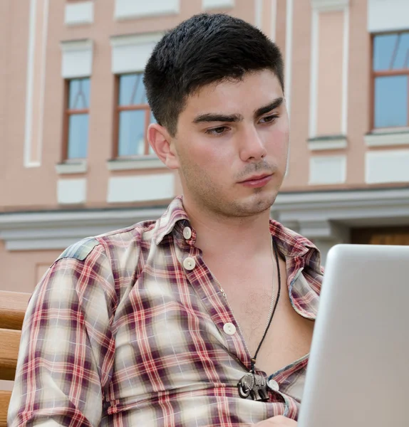 Ung man använder en bärbar dator — Stockfoto