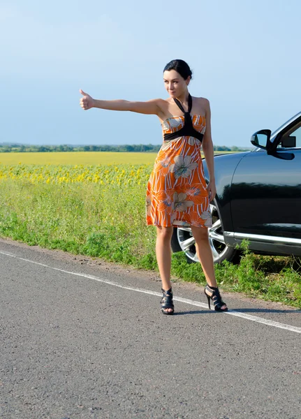 Woman hitchhiking after a breakdown — Stock Photo, Image