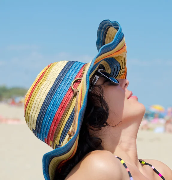 Жінка з капелюхом насолоджується на пляжі — стокове фото