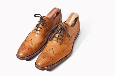 A pair of tan fashionable mens brogue shoes clipart