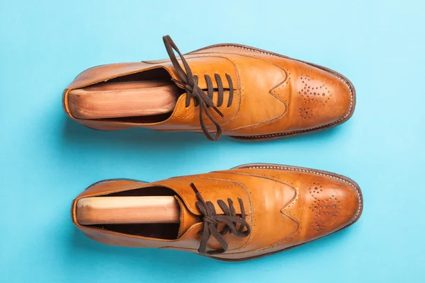 Ein Paar braune modische Herren Brogue Schuhe auf hellblauem Hintergrund — Stockfoto