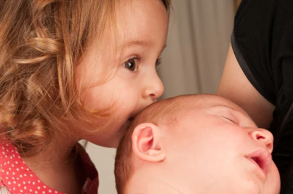 Поцелуй сестры-младенца — стоковое фото