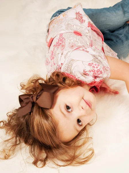 Cabelo encaracolado menina no chão — Fotografia de Stock