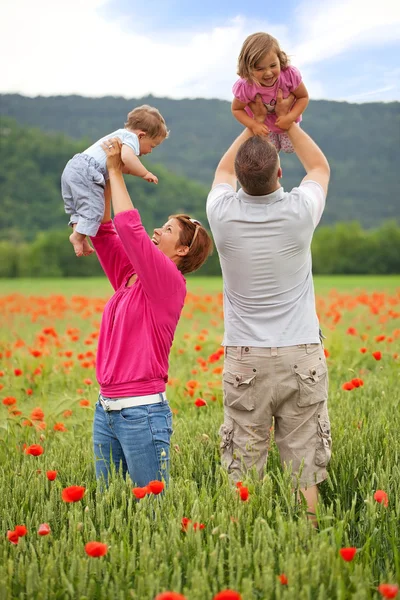 Family in poppy field — Stock Photo, Image