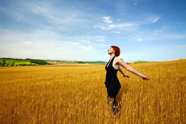 Женщина наслаждается пшеничным полем — стоковое фото