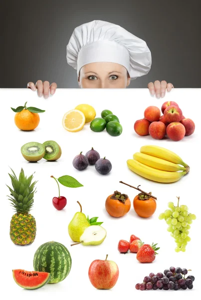 Vrouwelijke chef-kok kijkt uit over fruit billboard — Stockfoto