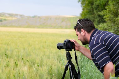 Photographer with tripod and DSLR camera clipart