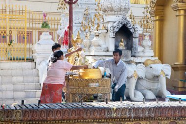 YANGON, MYANMAR - JAN 28. Buddhist devotees offering prayers. clipart