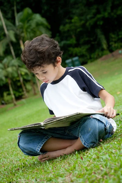 Kleiner Junge genießt sein Lesebuch im Freibad — Stockfoto