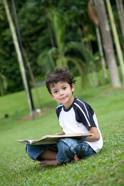 옥외 공원에서 책을 읽고 있는 소년 — 스톡 사진