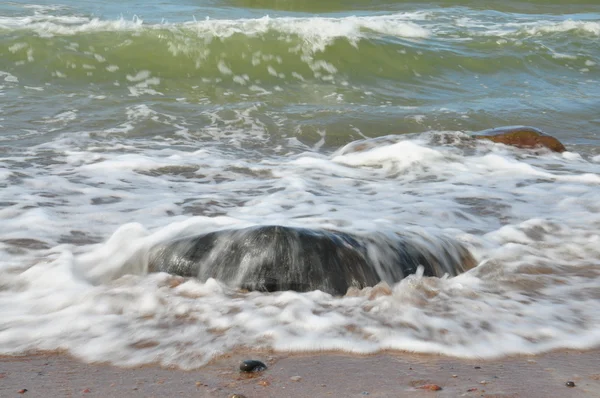 Stone shrouded in sea foam — Stock Photo, Image