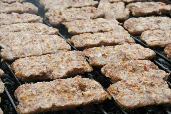 Жареная колбаса на гриле во время вечеринки на открытом воздухе с барбекю — стоковое фото