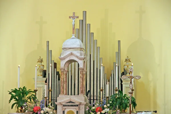 Interiör av en kyrkorgel, krucifix och blommor — Stockfoto