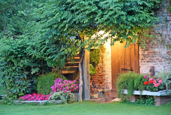 Večer světlo venkovský dům s květinami — Stock fotografie