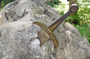 The legendary sword of King Arthur stuck in the rocks clipart
