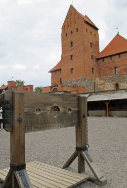 Yoke for the torture of witches and the Bell Tower in the backgr clipart