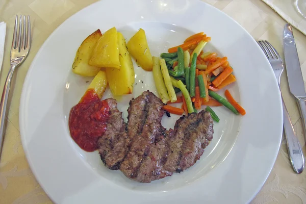 Jídlo v restauraci s masem a hranolky, smíchané Zeleninové plodiny — Stock fotografie