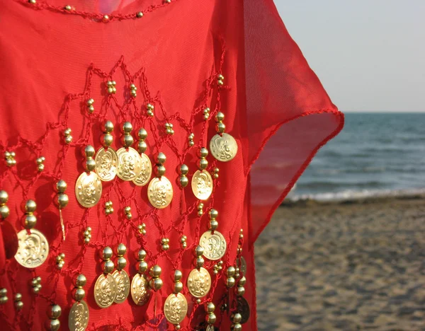 Dress with gold medals on the seashore — Stock Photo, Image