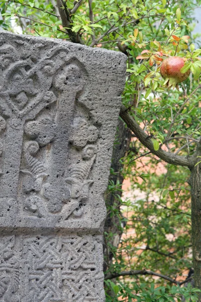 Kreuz aus Stein und Granatapfel — Stockfoto