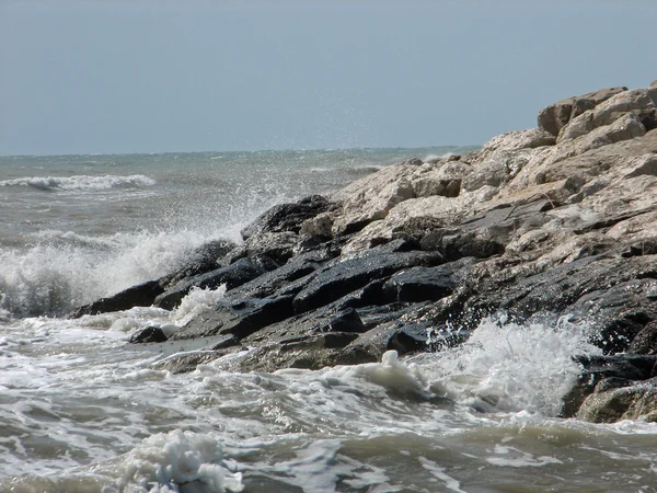 Splashing of the water of the Mediterranean Sea on the rocks on — Stock Photo, Image