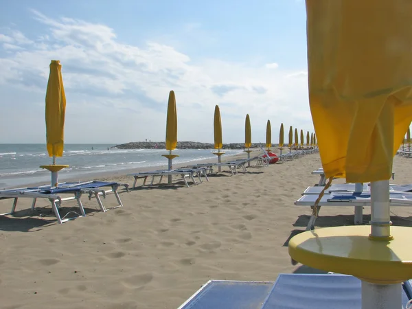 Guarda-chuvas, espreguiçadeiras e espreguiçadeiras na praia — Fotografia de Stock