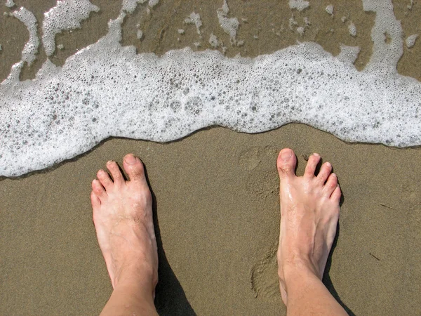 Dvě bosé nohy na pláži čeká na vlnu — Stock fotografie