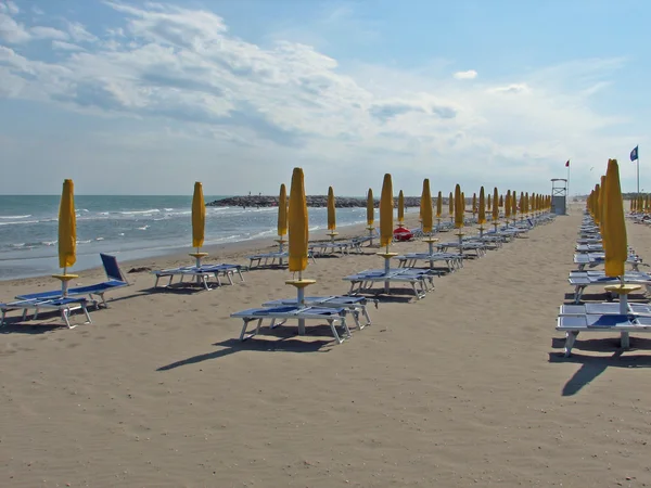 Зонтики, шезлонги и шезлонги на пляже — стоковое фото