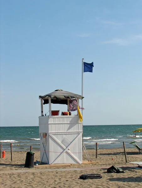 Věžička plavčíků a modrá vlajka — Stock fotografie