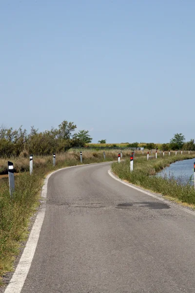Strada asfaltata stretta con curva in mezzo alla laguna di Ve — Foto Stock