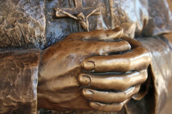 Hands of the statue of a priest who pray — Stock Photo, Image