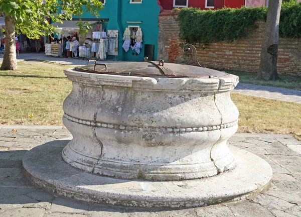 Antica fontana di marmo nella piazza di Burano Venezia — Foto Stock