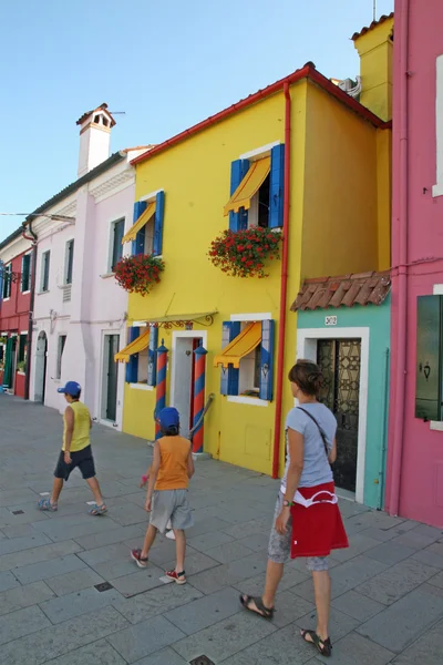 Family that walks in the midst of colorful houses on the island — Stock Photo, Image