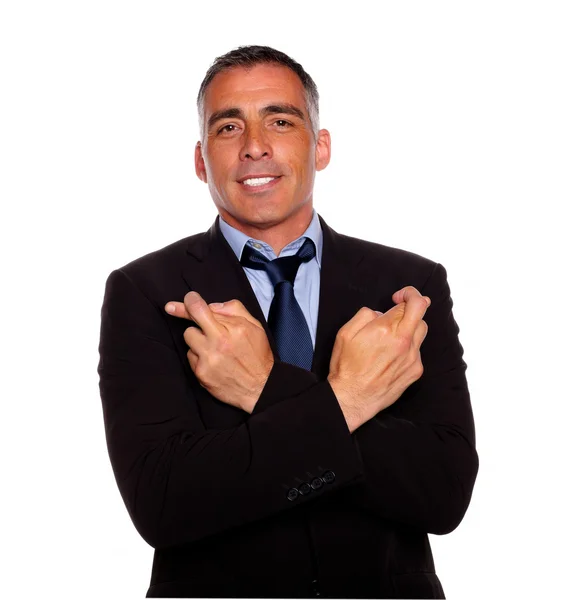 Adult latin man crossing arms and fingers — Stock Photo, Image