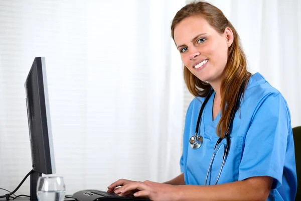 Дружня медсестра посміхається на робочому місці — стокове фото