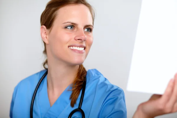Encantadora enfermeira bonita olhando para uma radiografia — Fotografia de Stock