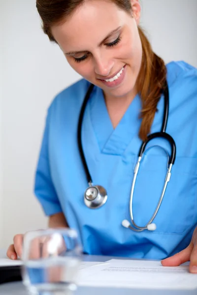 Красивая блондинка-медсестра улыбается стетоскопом — стоковое фото
