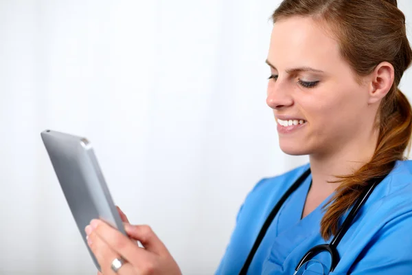 Mooie chirurg vrouw die lacht met een tablet pc — Stockfoto