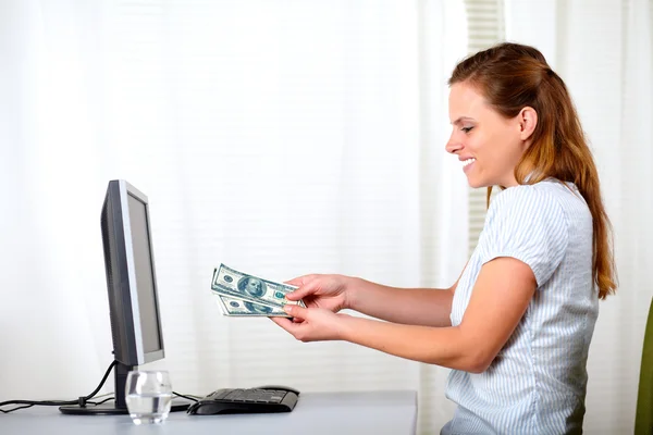 Hübsche blonde Frau mit Geld im Büro — Stockfoto