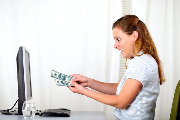 Mujer hermosa sorprendida mirando a los dólares — Foto de Stock