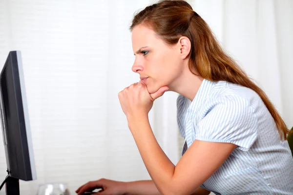 Charming pensive pretty girl looking on computer Royalty Free Stock Images