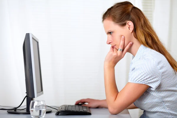 Schöne blonde Frau liest am Computer — Stockfoto