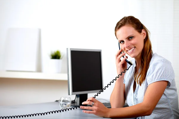 Secretária loira amigável falando por telefone — Fotografia de Stock
