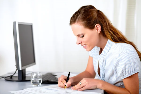 Lovely blonde lady writing at workplace — Stock Photo, Image