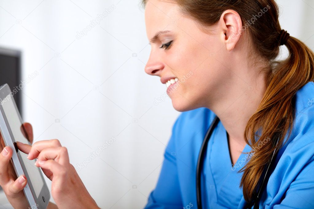 Beautiful friendly nurse smiling with a tablet PC