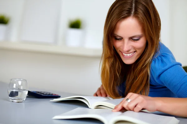 Mujer estudiante rubia bonita sonriendo y leyendo —  Fotos de Stock