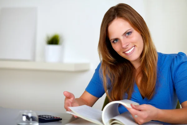 Schöne junge Frau liest zu Hause ein Buch — Stockfoto