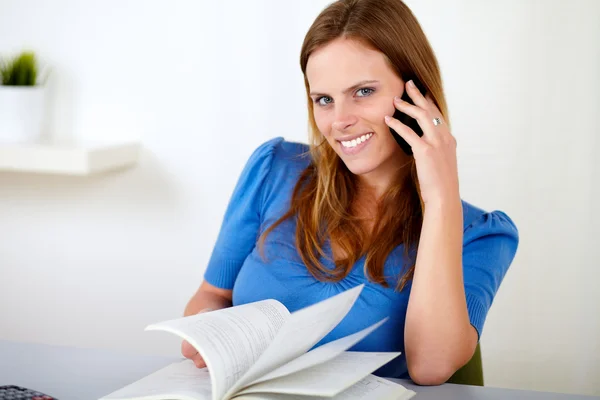 Blonde girl on cellphone while studying — Stock Photo, Image