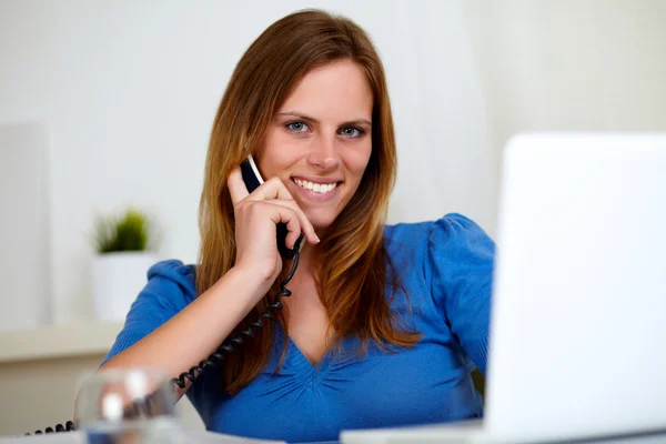 Hübsche junge Frau lächelt am Telefon — Stockfoto