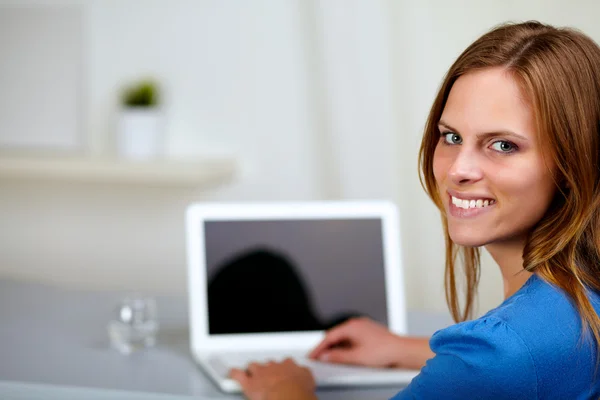 Menina sorrindo e trabalhando no laptop — Fotografia de Stock